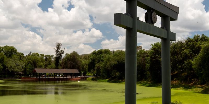 A serene natural landscape with calm water reflecting the sky, symbolizing harmony.