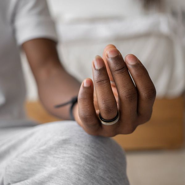 Close-up of a person's hands in a mindful gesture during yoga practice.
